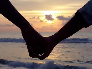 Holding hands in front of ocean